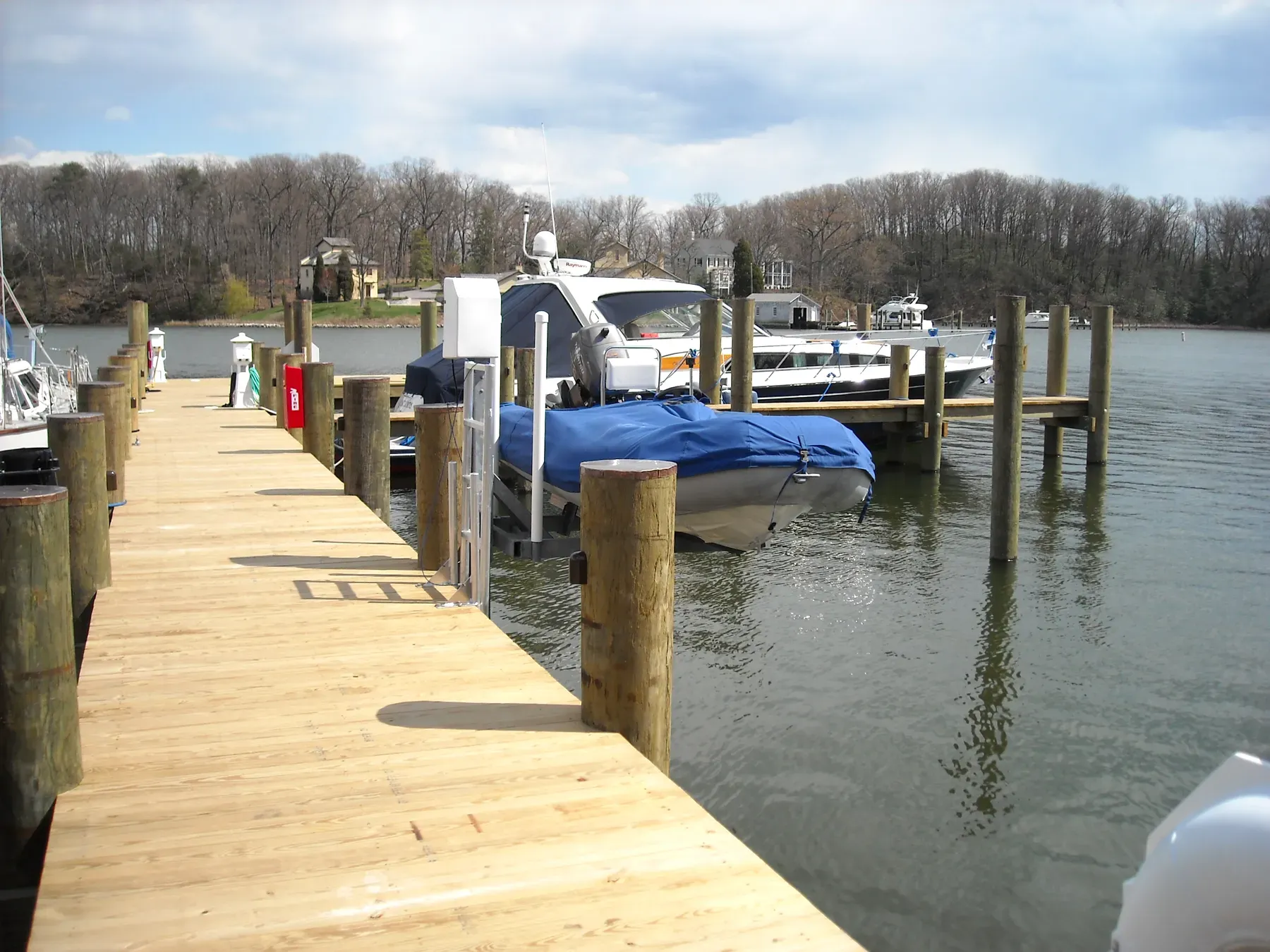 Long new pier with boats moored along it on the river